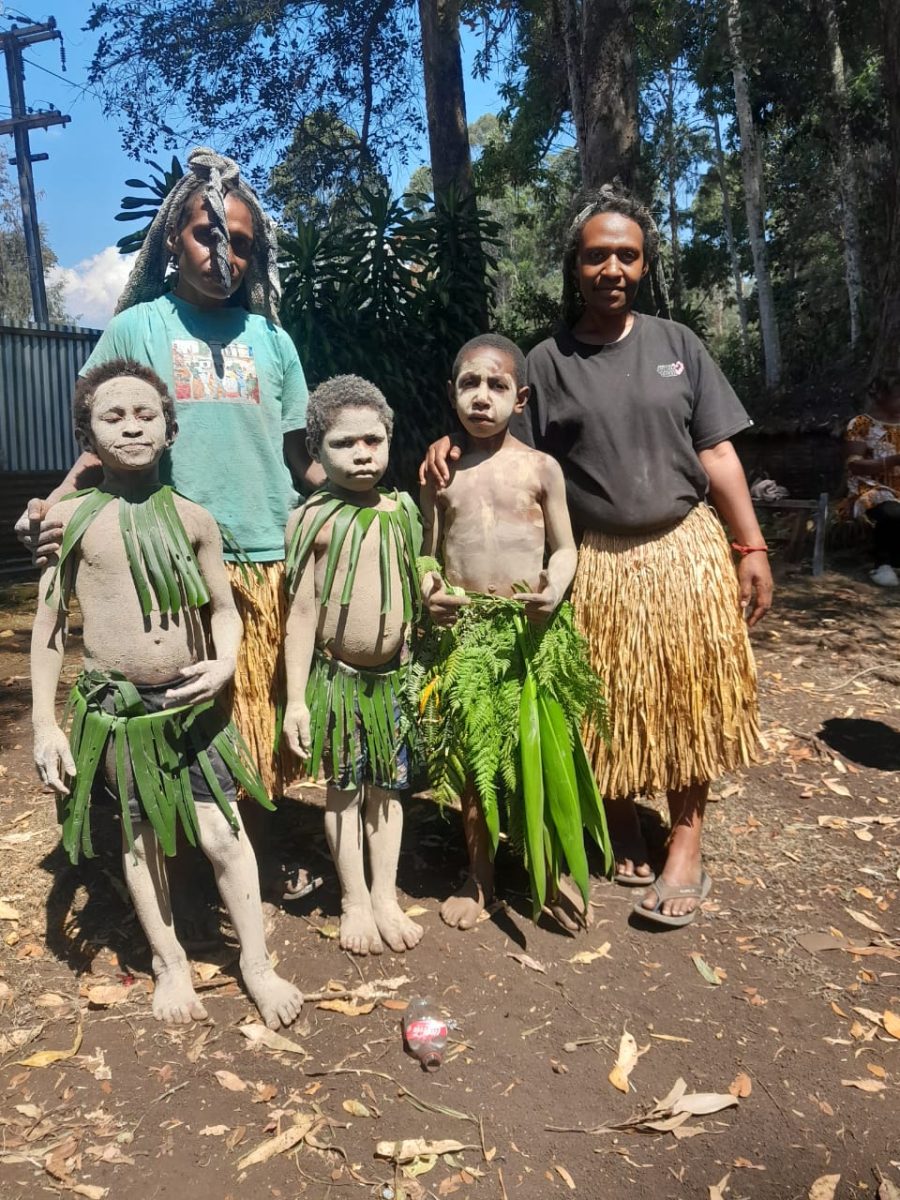 Children in traditional leaf bilas with their mothers